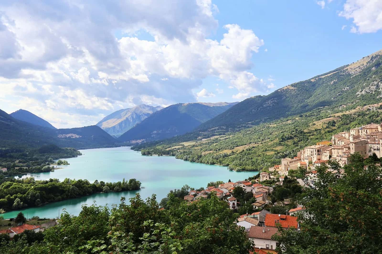 Le lac de Barrea turquoise et le village de Villetta Barrea accroché au versant, dans le parc national des Abruzzes