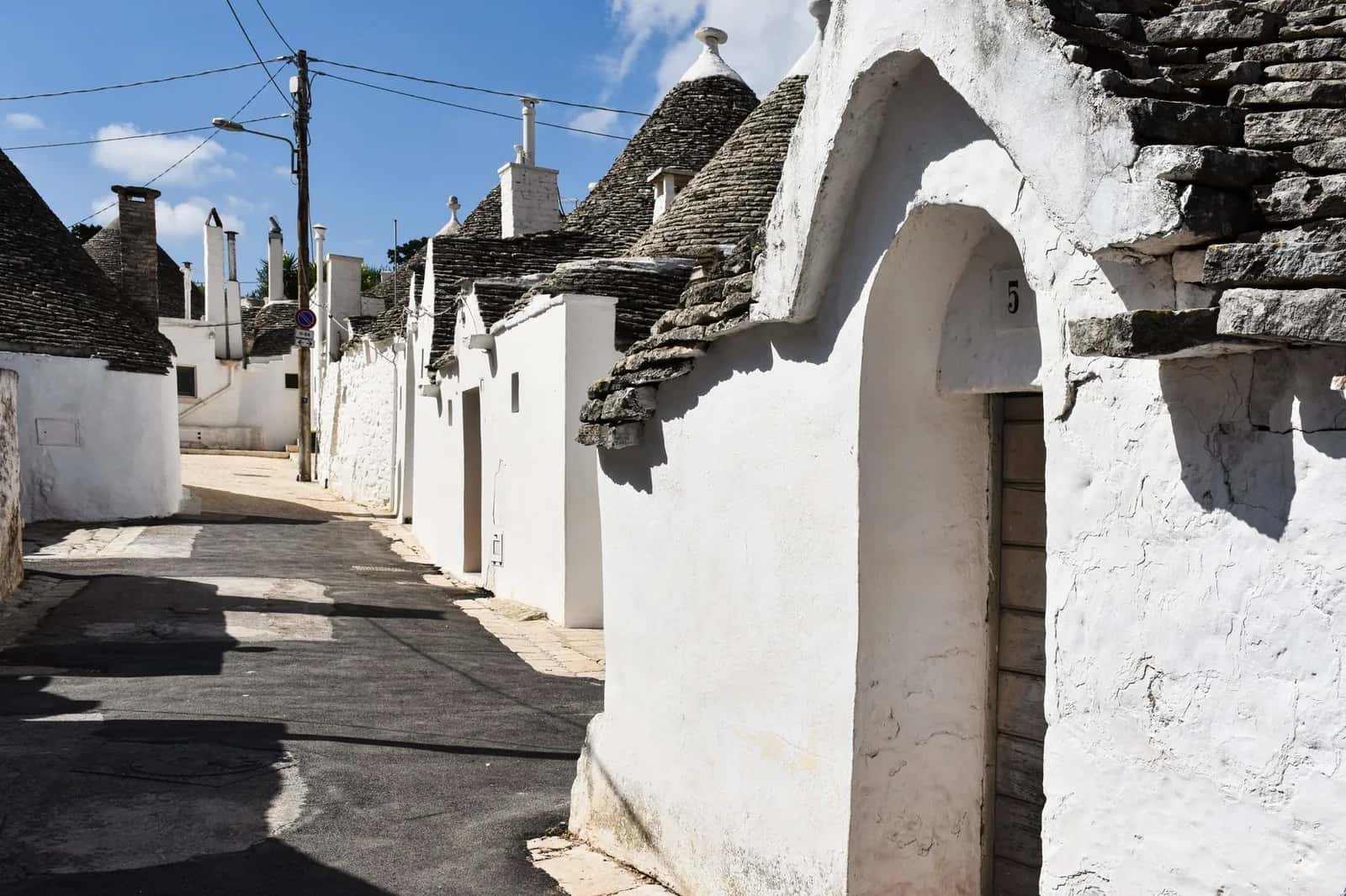 Ruelle en pente bordée de trulli blancs dans le Rione Monti à Alberobello