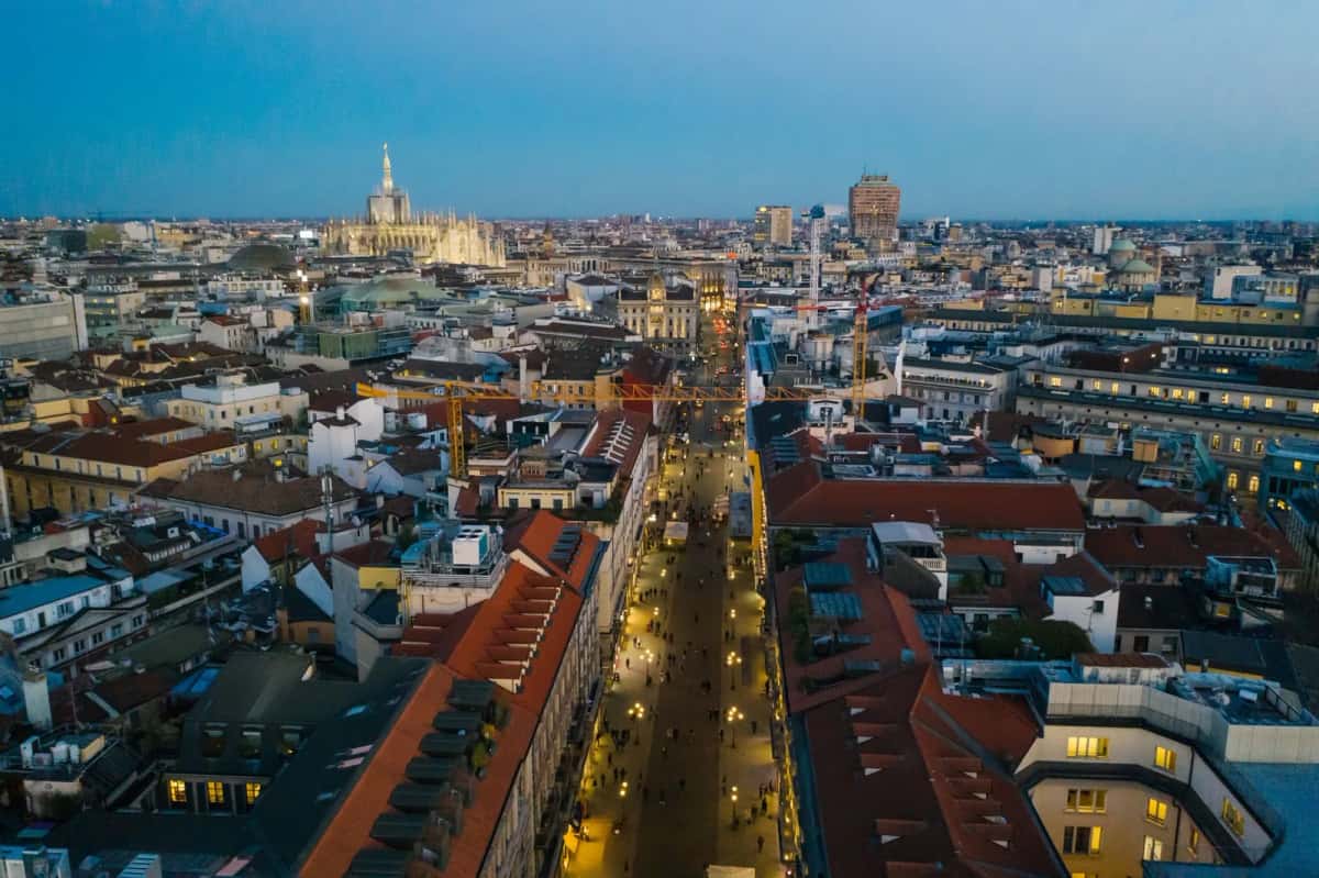 Vue aérienne du centre de Milan au crépuscule, avec le Duomo illuminé et les tours du quartier des affaires, dans le nord de l'Italie