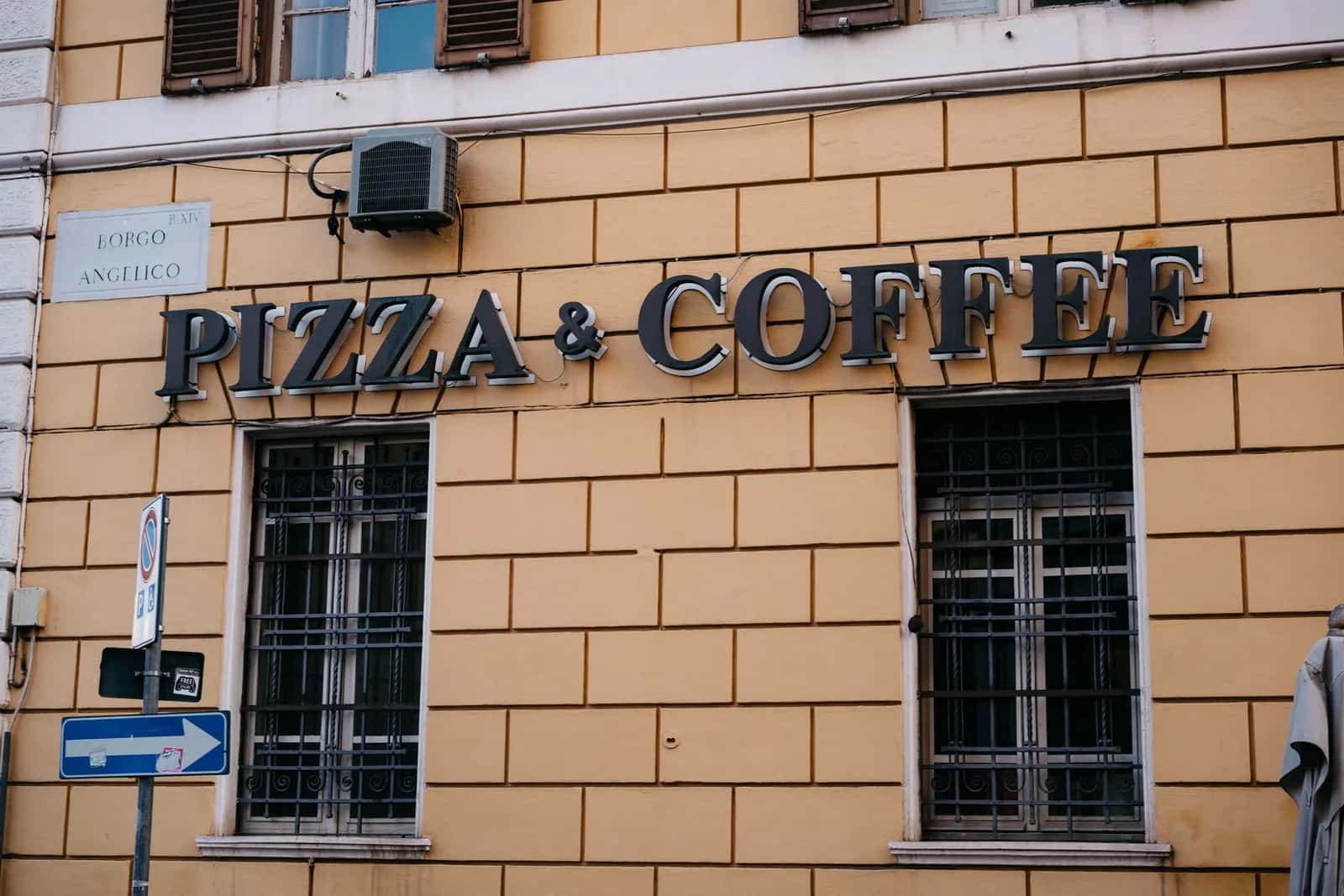 Enseigne Pizza & Coffee sur une façade ocre du Borgo Angelico, près du Vatican, à Rome en Italie