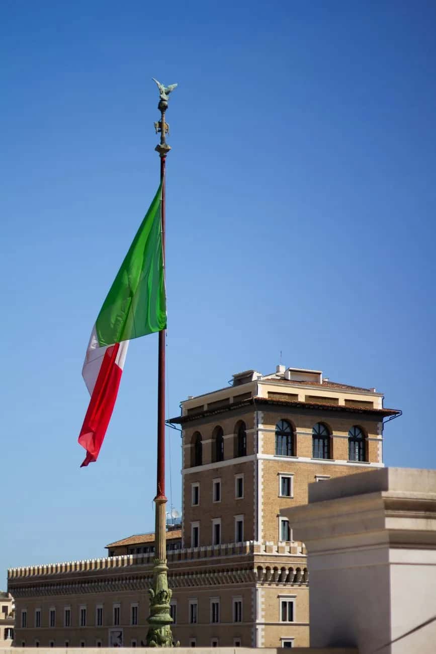 Le drapeau de l'Italie flottant sur son mât devant le Palazzo Venezia à Rome