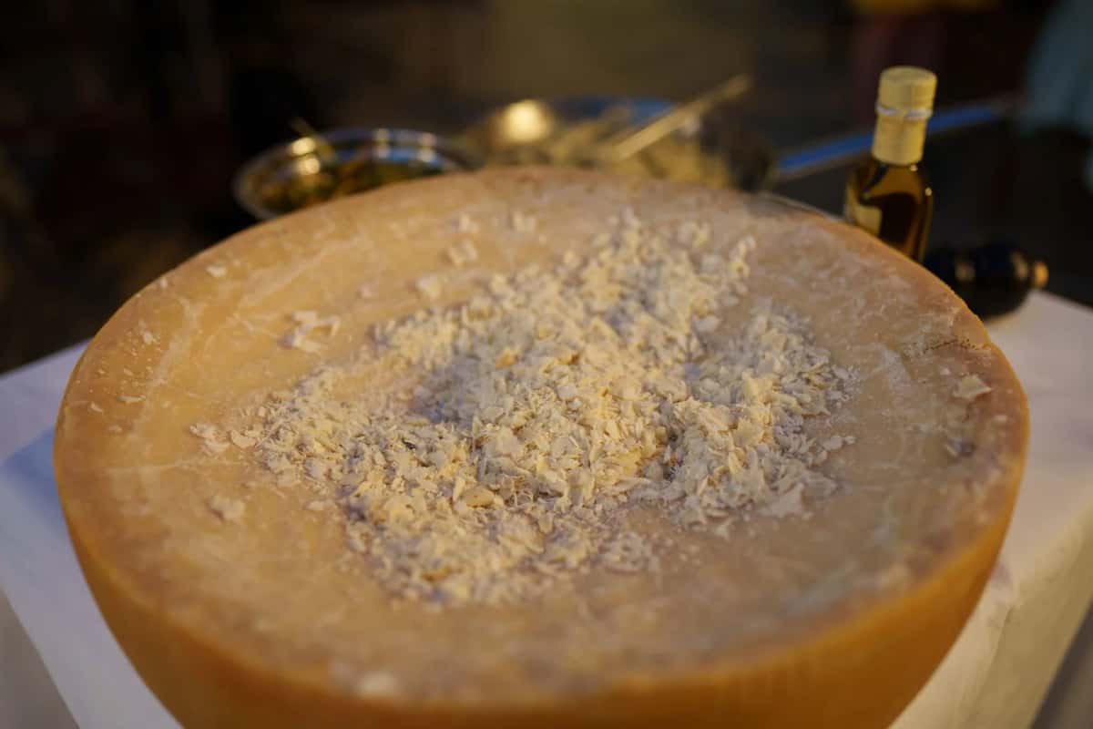 Une meule de Parmigiano Reggiano entière avec des éclats de parmesan, spécialité emblématique de l'Émilie-Romagne