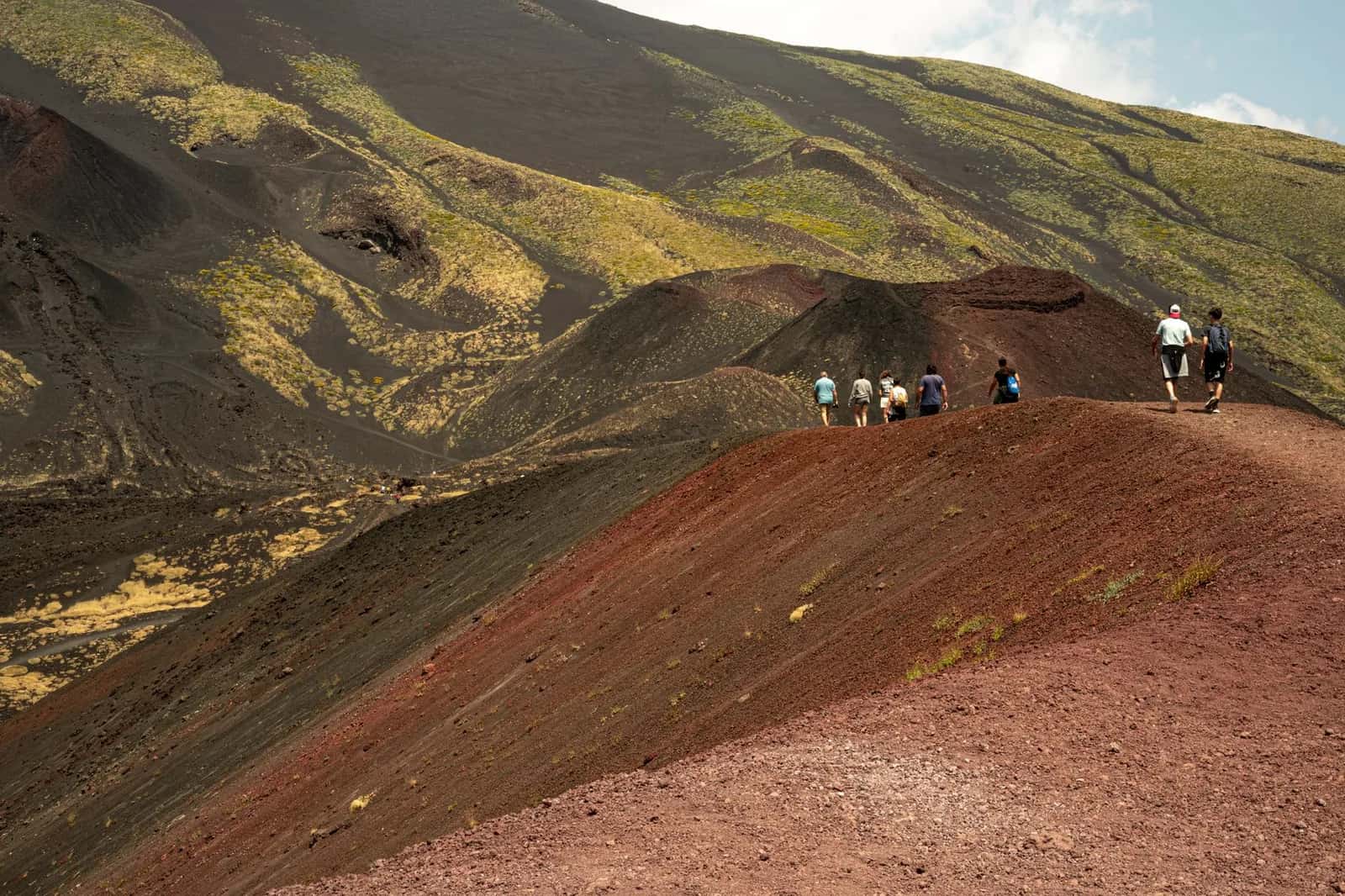 Randonneurs sur la crête d'un cône de scories rouges et noires sur le versant sud de l'Etna, en Sicile