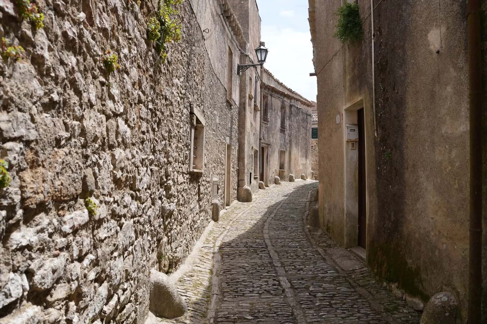 Ruelle pavée bordée de murs en pierre dans le centre historique d'un village italien
