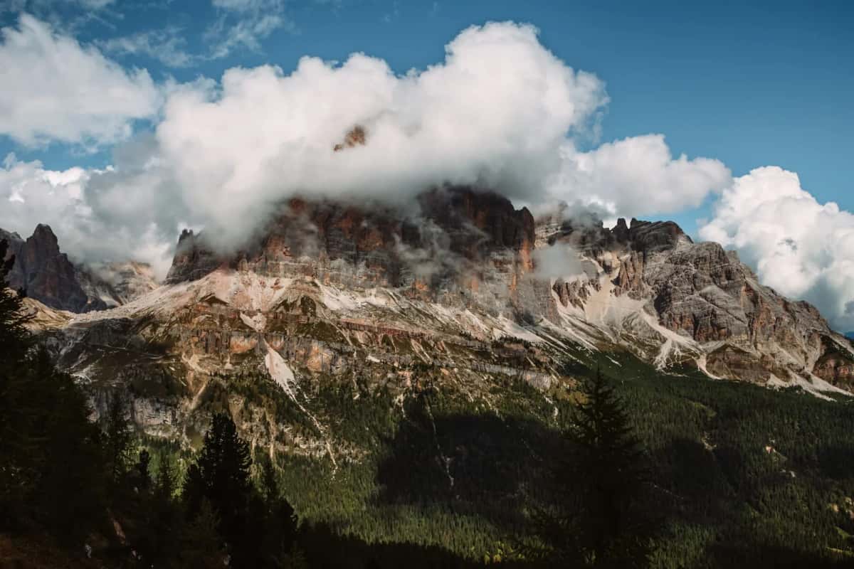 Un sommet des Dolomites enveloppé de nuages au-dessus des forêts, dans le Nord de l'Italie