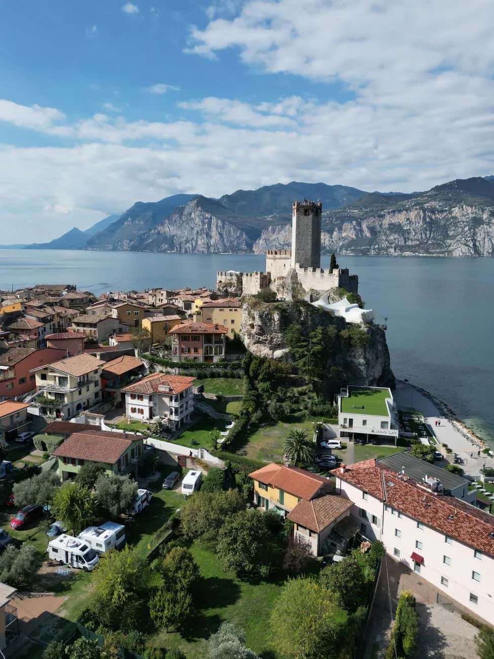 Le château Scaligero de Malcesine perché sur son éperon rocheux au-dessus du lac de Garde, avec les montagnes en arrière-plan, en Italie