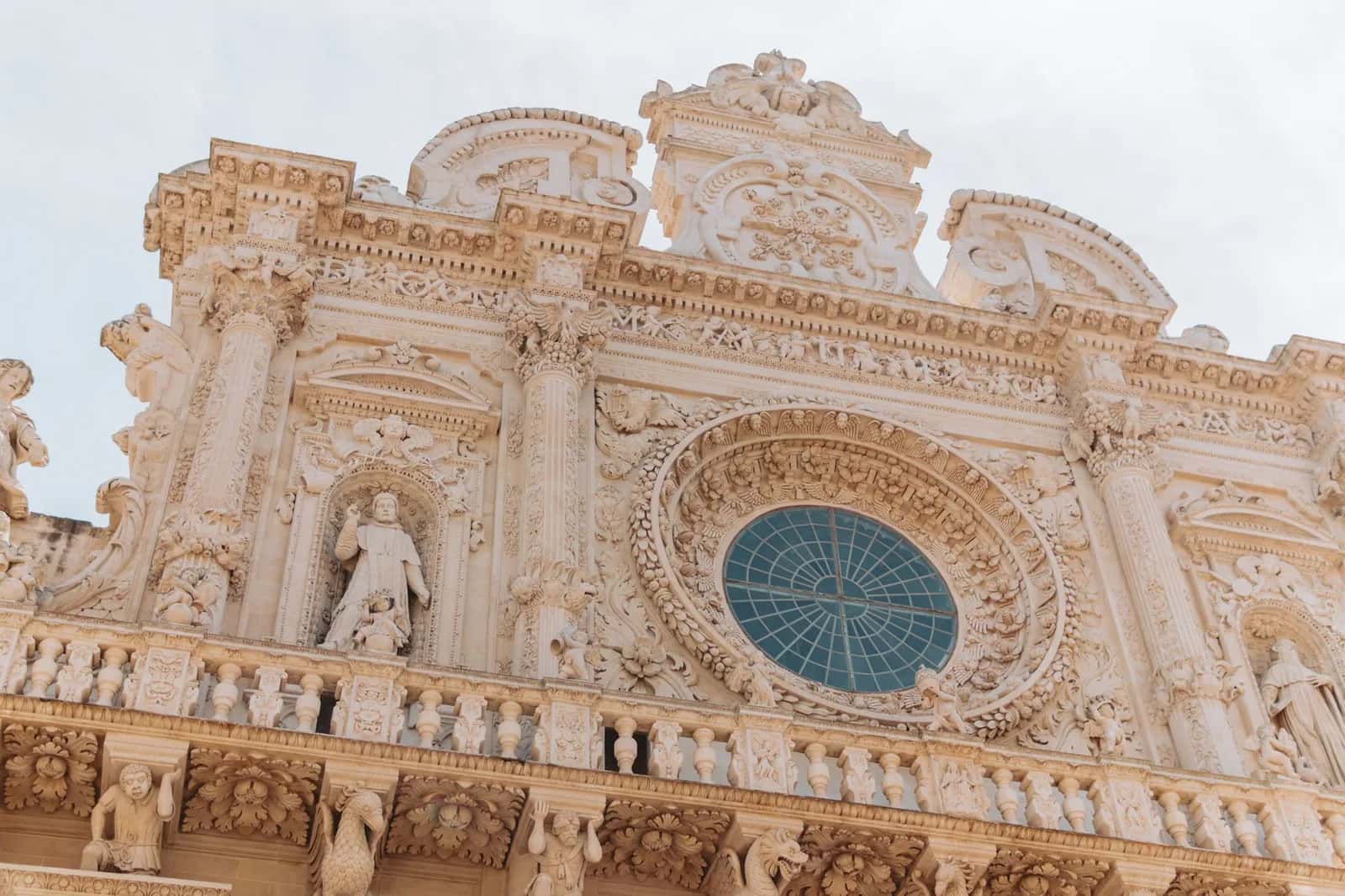 Façade baroque sculptée de la basilique Santa Croce à Lecce, avec sa rosace et ses statues en pierre dorée