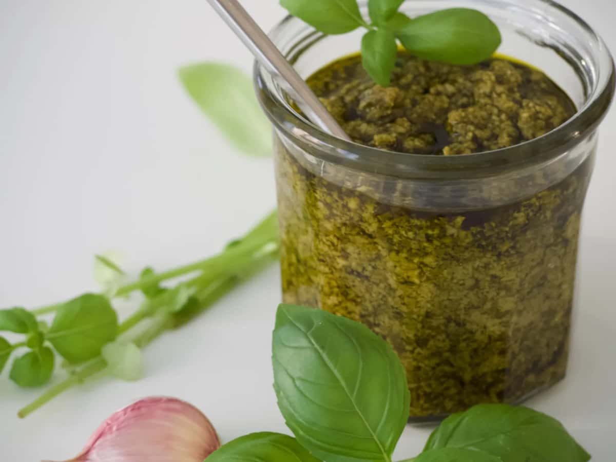 Pot de pesto alla genovese avec feuilles de basilic frais et gousse d'ail, spécialité de Ligurie