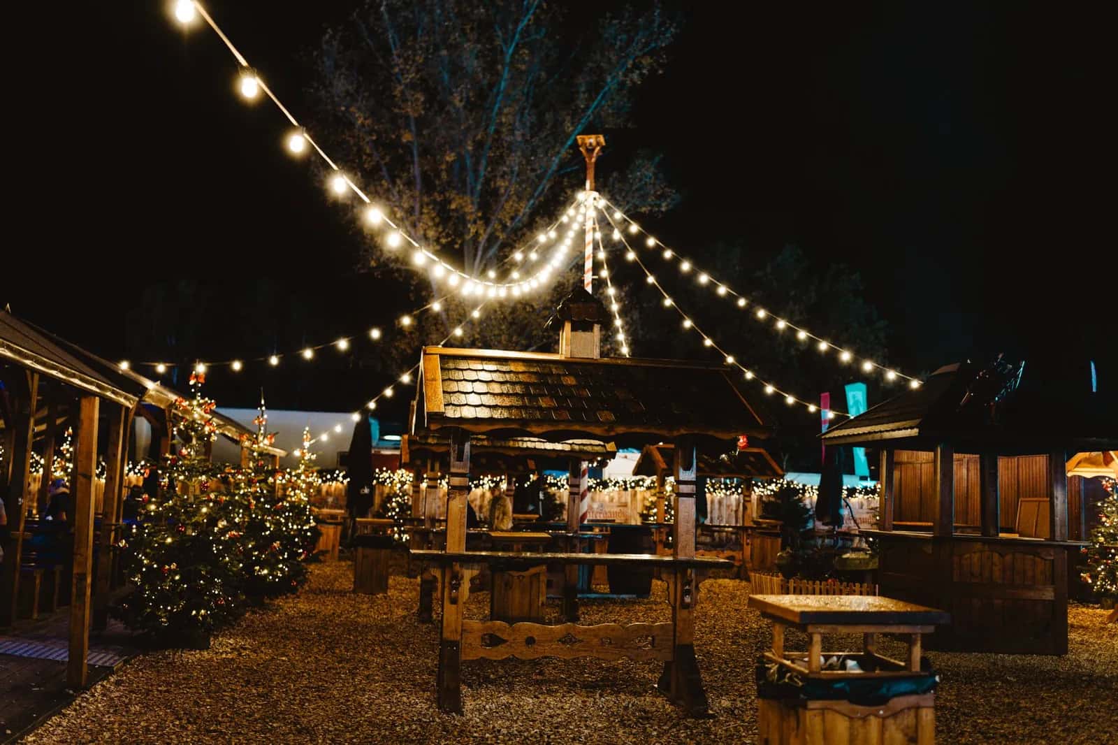 Chalets en bois et guirlandes lumineuses d'un marché de Noël du nord de l'Italie, de nuit
