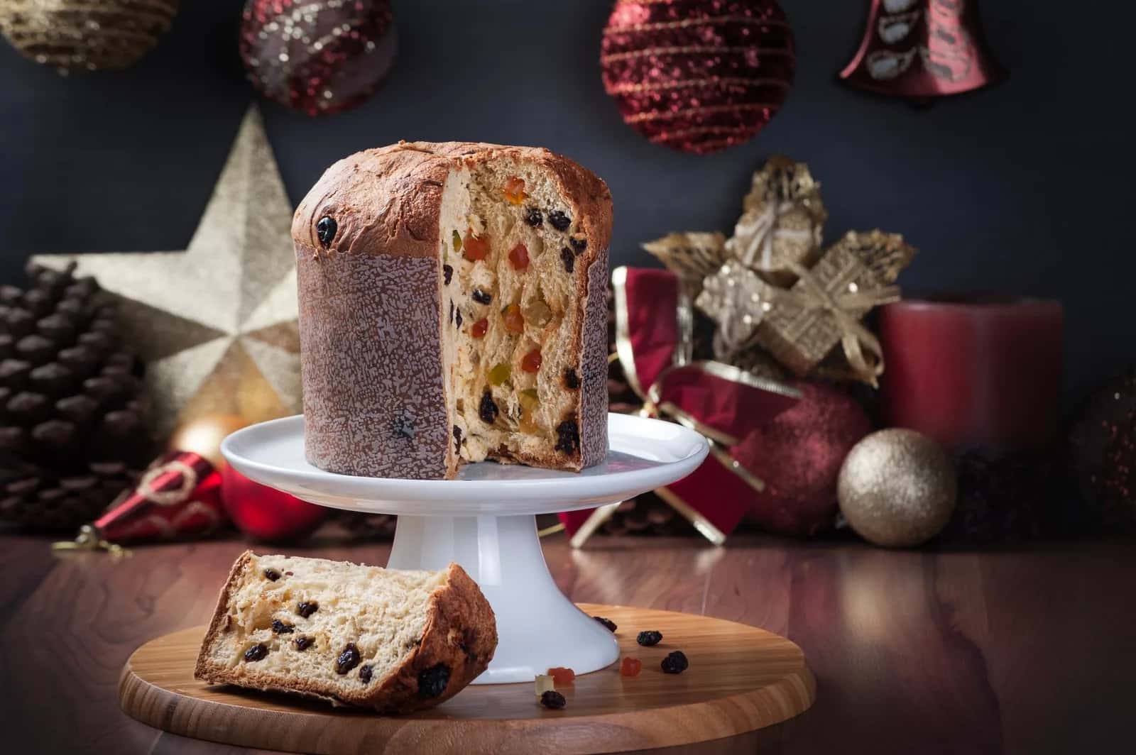 Panettone tranché sur un plat de service, parmi les décorations de Noël italiennes