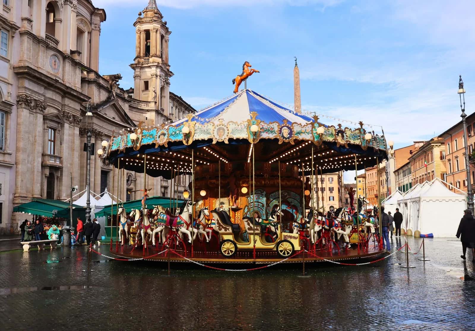 Manège de Noël sur la piazza Navona à Rome, avec l'obélisque et les stands du marché en arrière-plan
