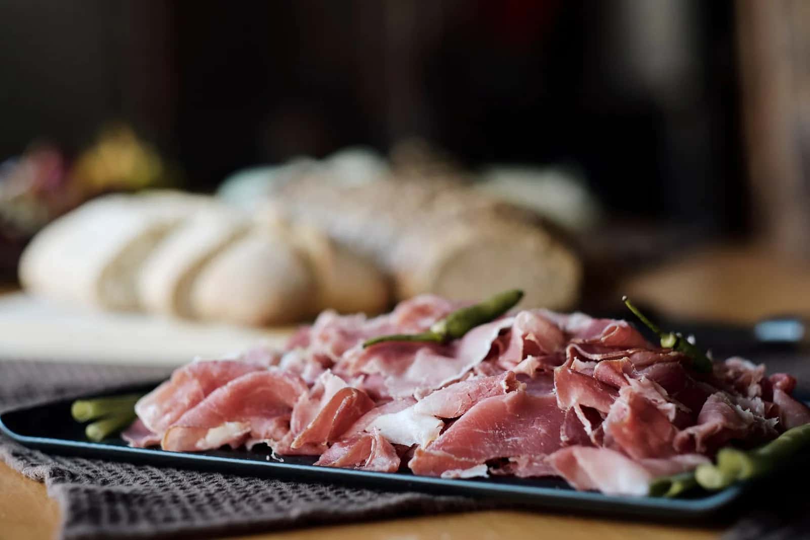 Assiette de jambon cru finement tranché servi avec du pain