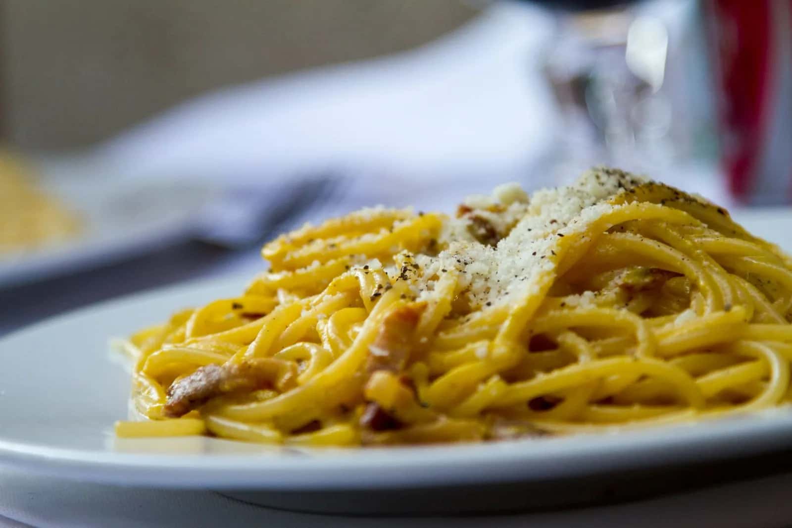 Assiette de spaghetti alla carbonara à la romaine, sauce jaune, pecorino râpé, poivre noir et guanciale