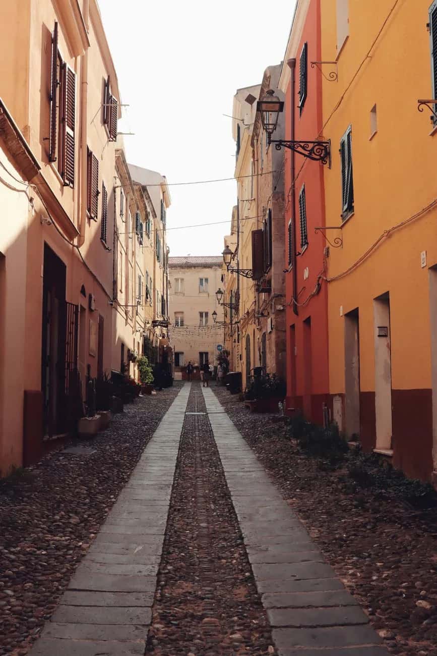Ruelle pavée bordée de façades colorées dans la vieille ville catalane d'Alghero, en Sardaigne