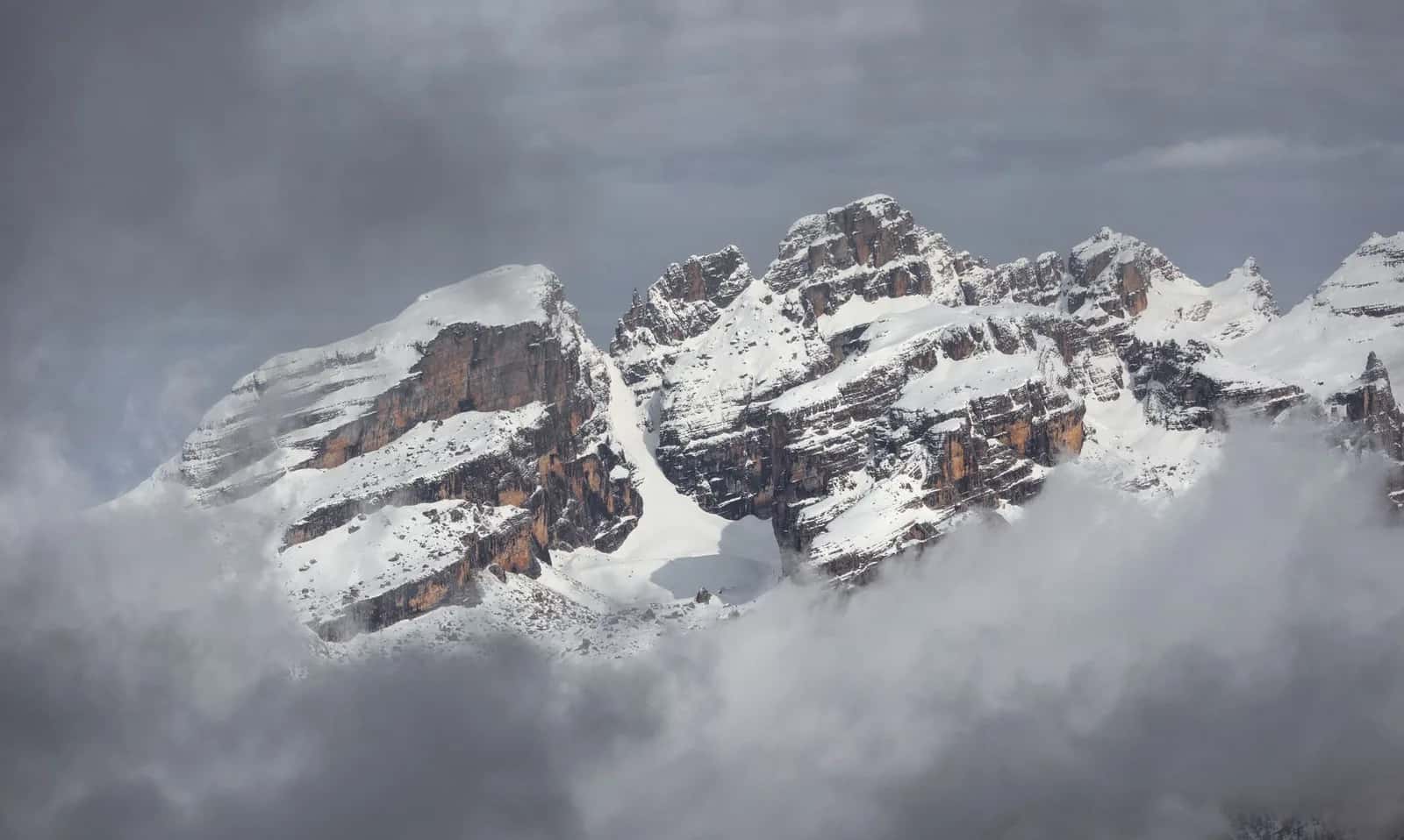 Sommets enneigés des Dolomites de Brenta émergeant des nuages, au-dessus de Madonna di Campiglio