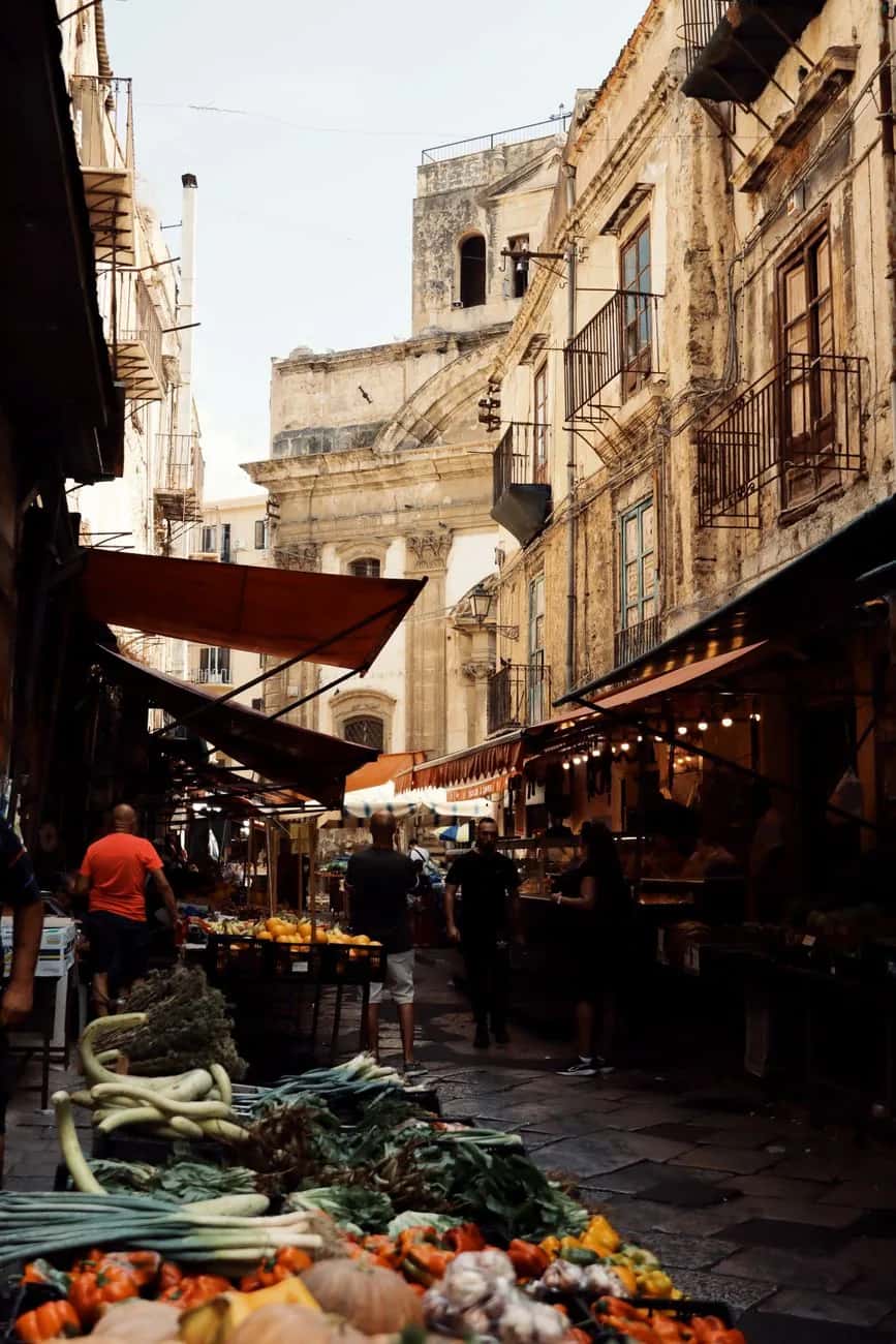 Ruelle du marché de Ballarò à Palerme avec ses étals de légumes et ses auvents, quartier du street food sicilien