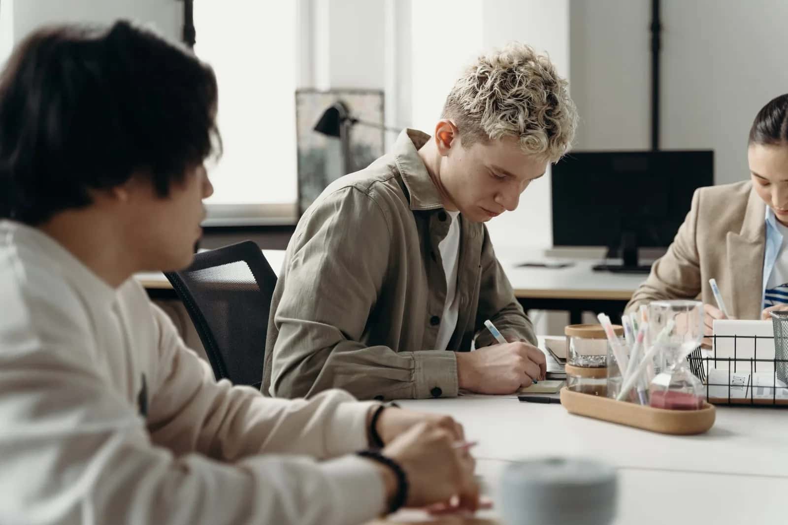Jeunes stagiaires au travail autour d'une table dans les bureaux d'une entreprise en Italie